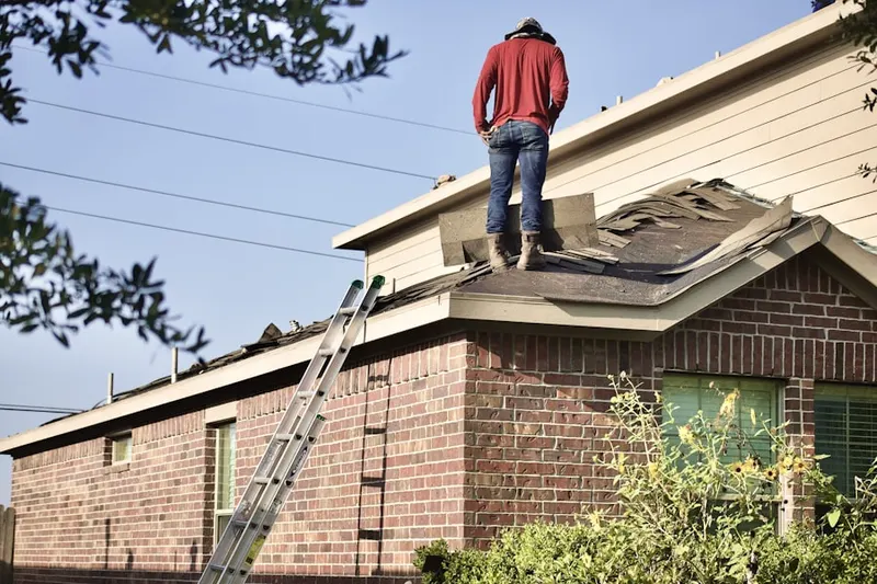 Professional roofer working on a residential roof in Apulia Station